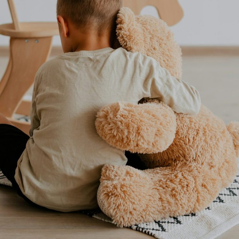 Kind mit Teddybär in einer spieltherapeutischen Situation
